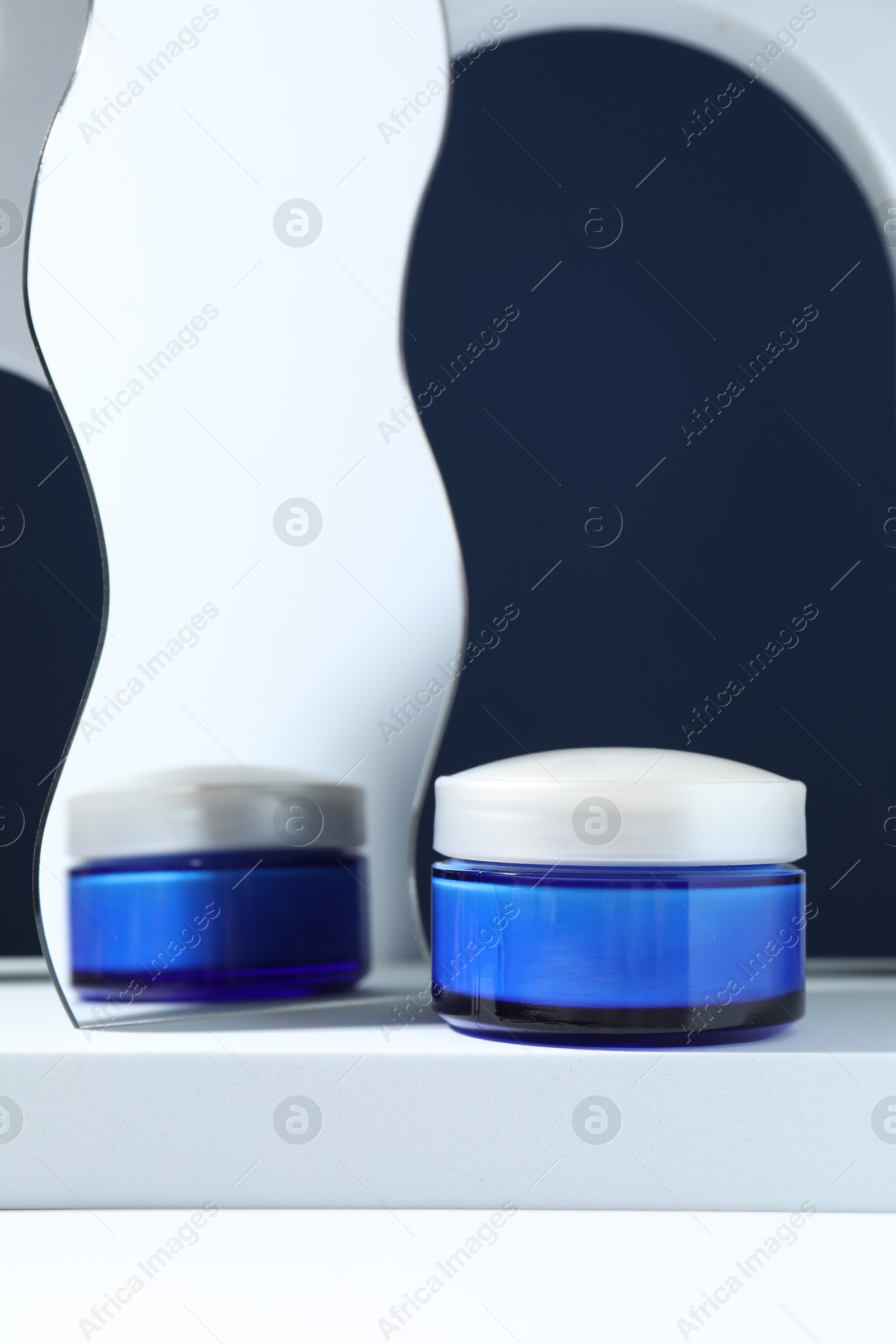 Photo of Stylish presentation of face cream against blue background