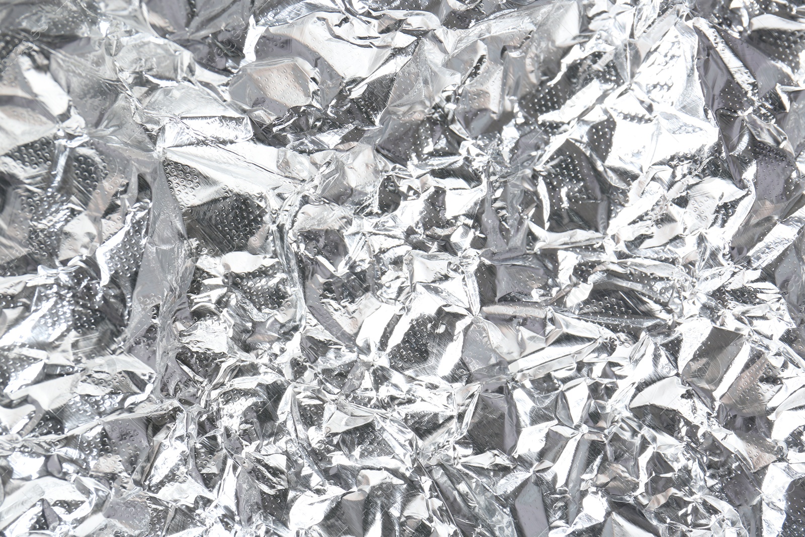 Photo of Shiny silver tinfoil surface as background, closeup