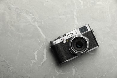 Vintage photo camera on grey marble table, top view. Space for text