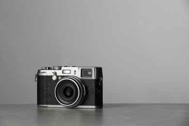 Vintage photo camera on grey table, space for text