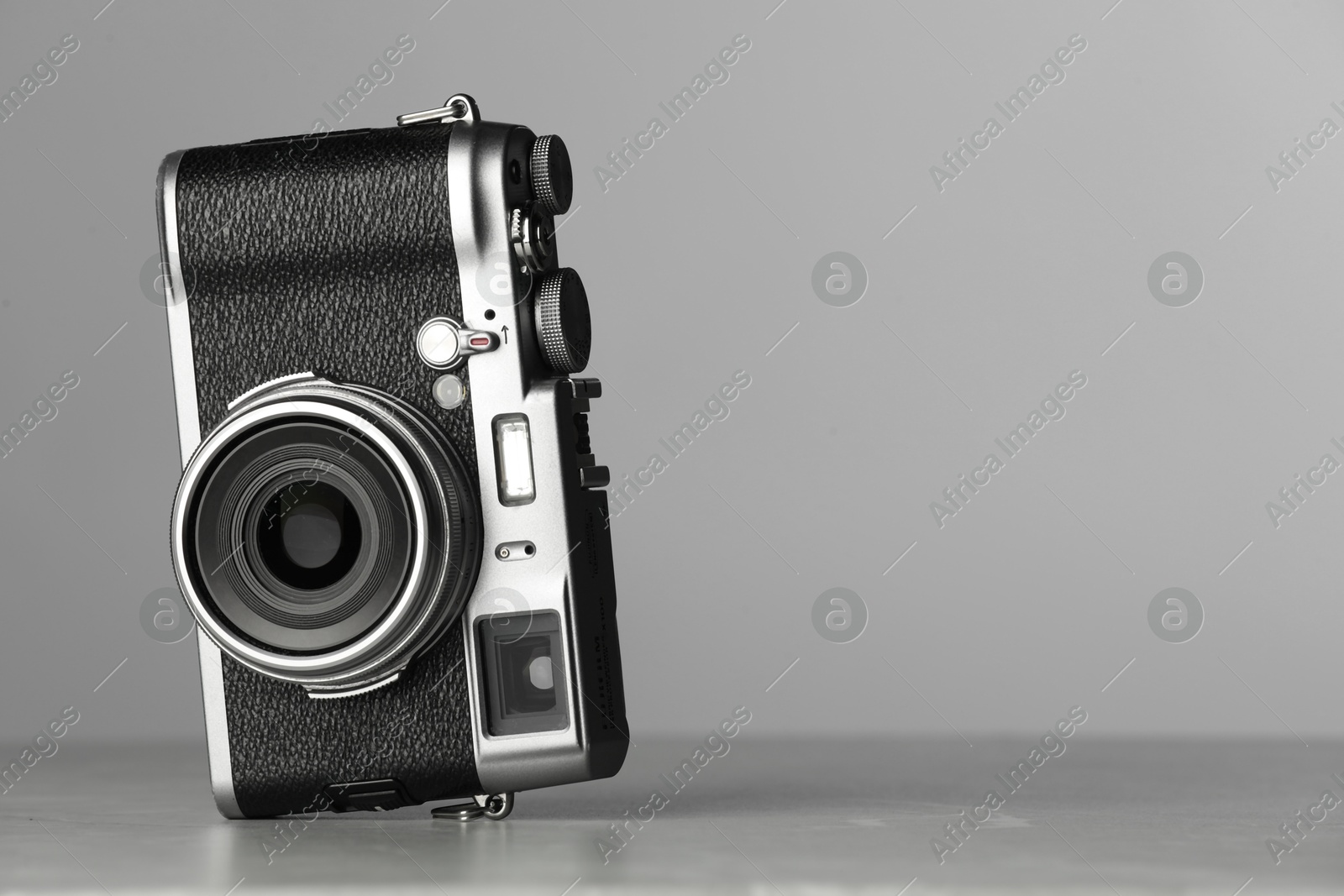 Photo of Vintage photo camera on grey table, space for text