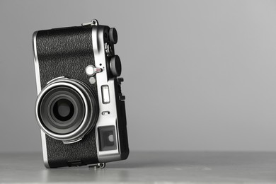 Vintage photo camera on grey table, space for text