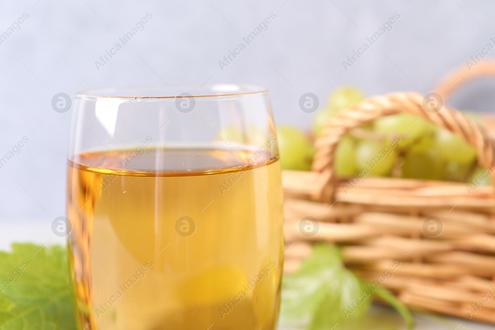 Photo of Tasty grape juice in glass on blurred background, closeup