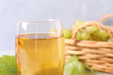 Photo of Tasty grape juice in glass on blurred background, closeup