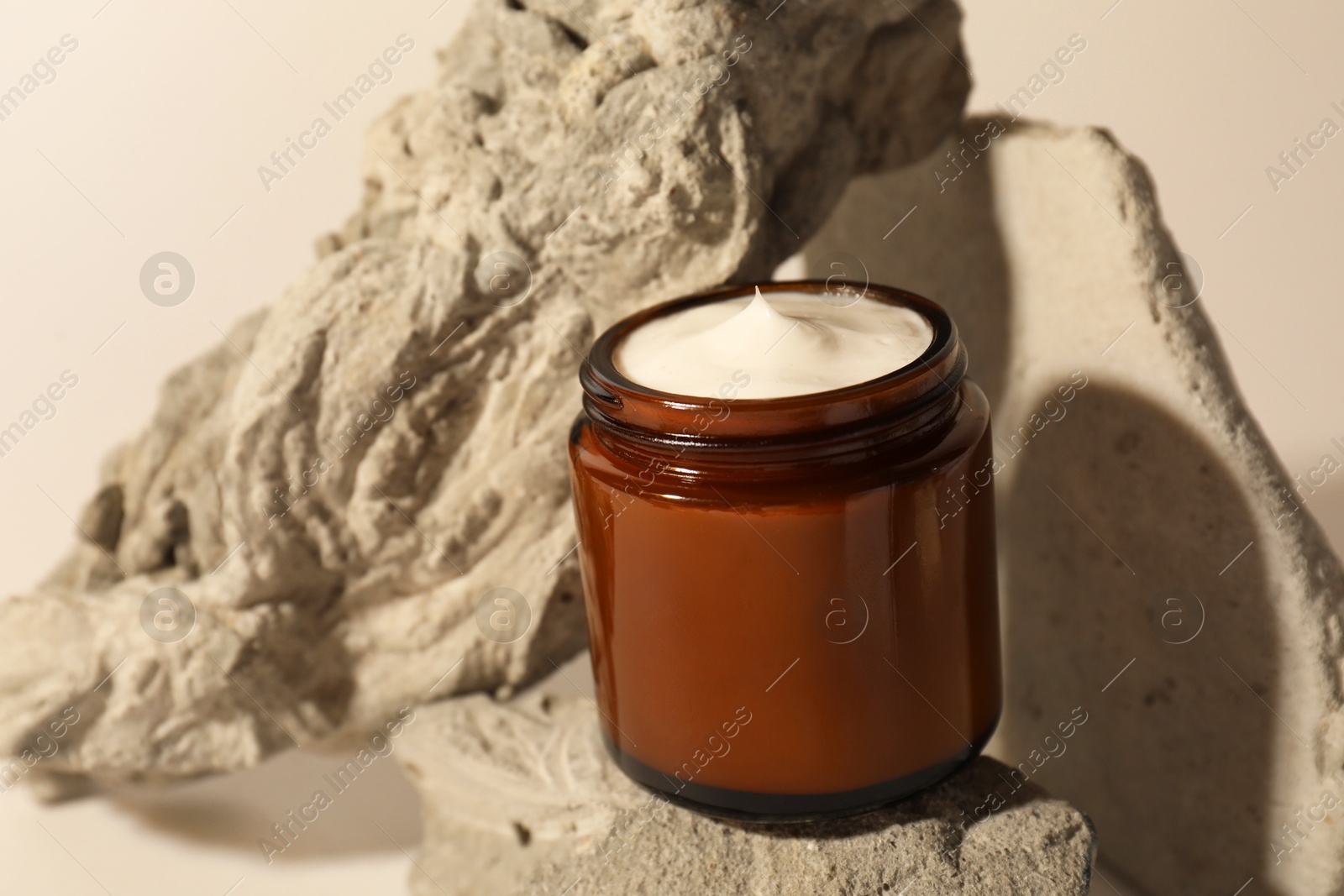 Photo of Stylish presentation of facial cream on beige background, closeup