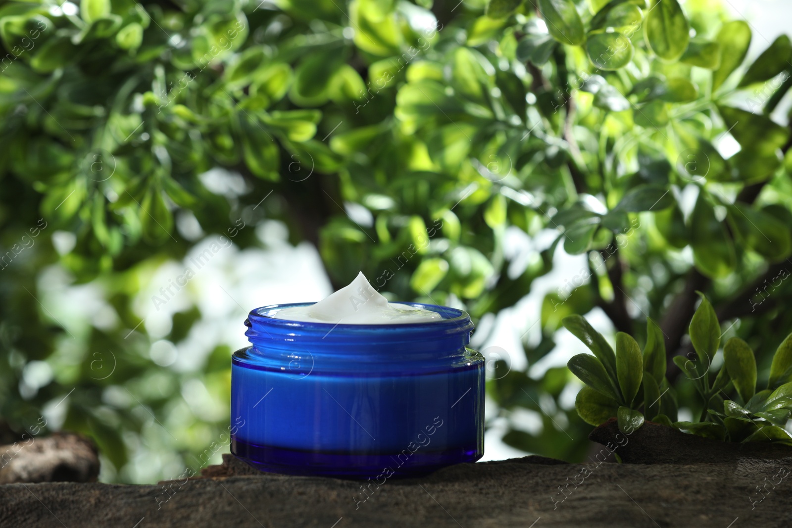 Photo of Stylish presentation of facial cream in jar outdoors