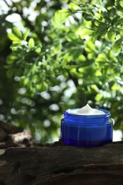 Stylish presentation of facial cream in jar outdoors, closeup. Space for text