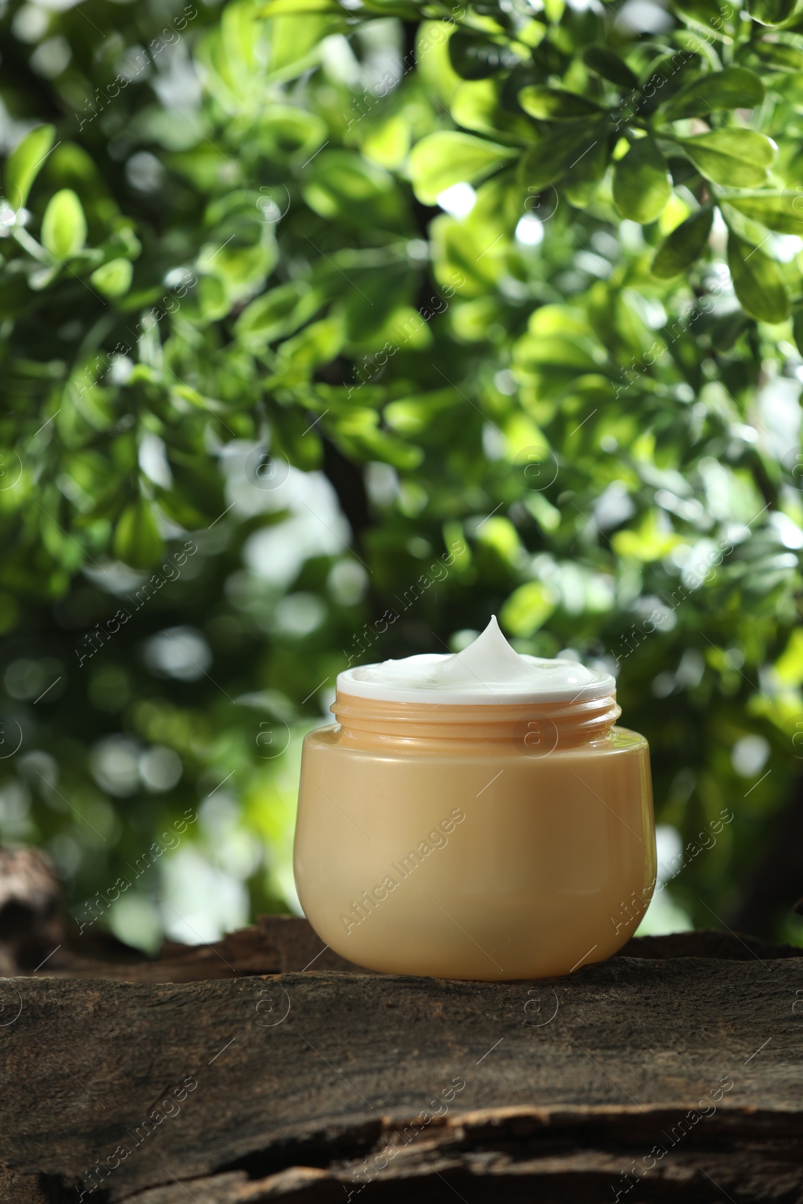 Photo of Stylish presentation of facial cream in jar outdoors