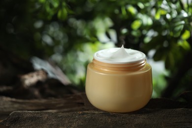 Stylish presentation of facial cream in jar outdoors, closeup. Space for text