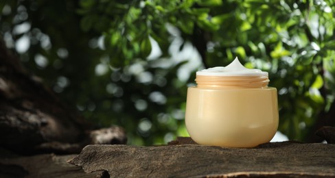 Stylish presentation of facial cream in jar outdoors, closeup. Space for text