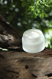 Photo of Stylish presentation of facial cream in jar outdoors