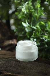 Photo of Stylish presentation of facial cream in jar outdoors