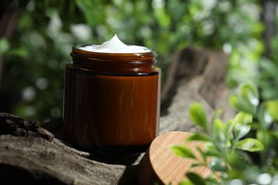 Stylish presentation of facial cream in jar outdoors, closeup