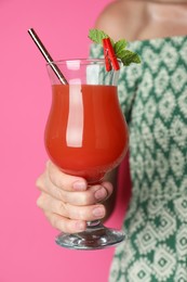 Photo of Woman with glass of refreshing cocktail on pink background, closeup