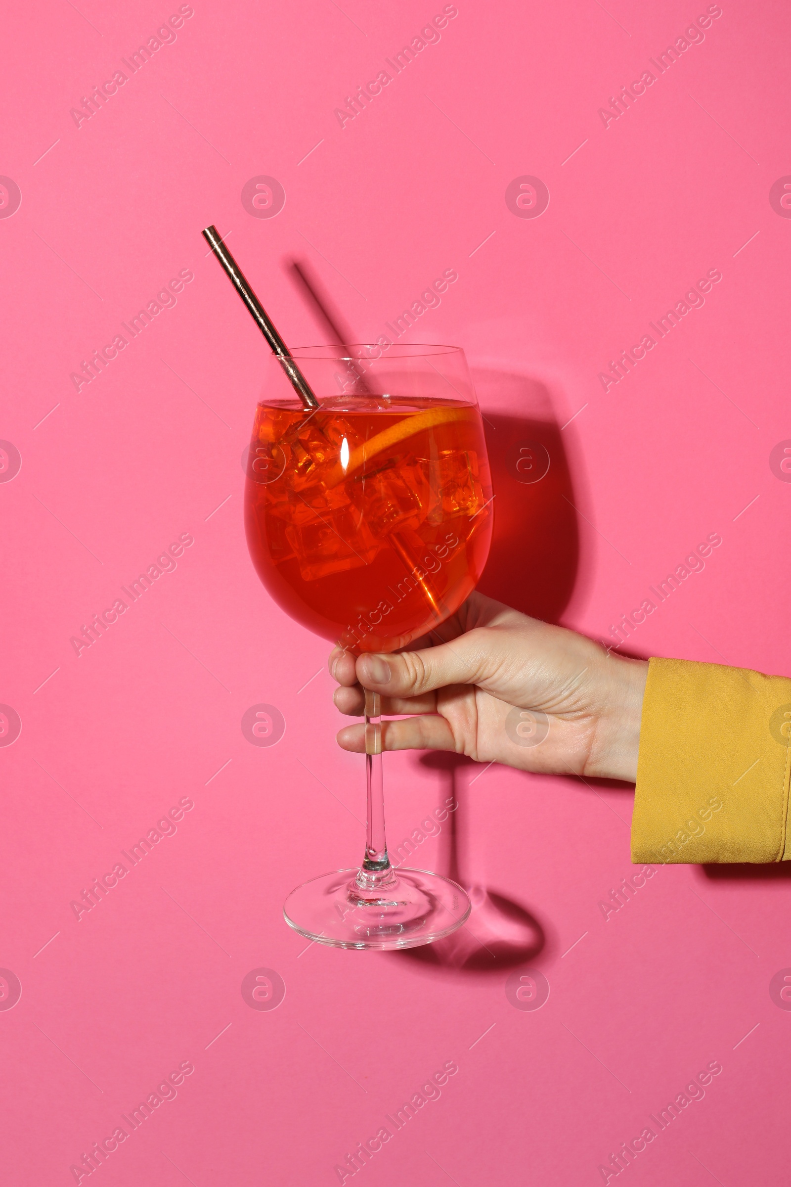 Photo of Woman with glass of refreshing cocktail on pink background, closeup