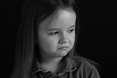 Photo of Portrait of sad girl on dark background, closeup. Black and white effect