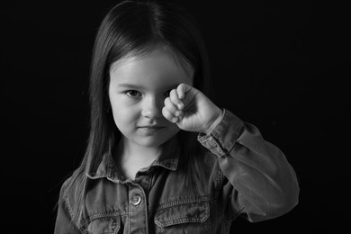 Portrait of sad girl on dark background, closeup. Black and white effect