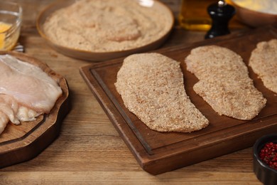 Making schnitzels. Raw meat and other ingredients on wooden table, closeup