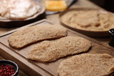 Making schnitzels. Raw meat and other ingredients on wooden table, closeup