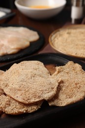 Making schnitzels. Raw meat and other ingredients on wooden table, closeup