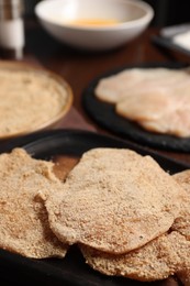 Making schnitzels. Raw meat and other ingredients on wooden table, closeup