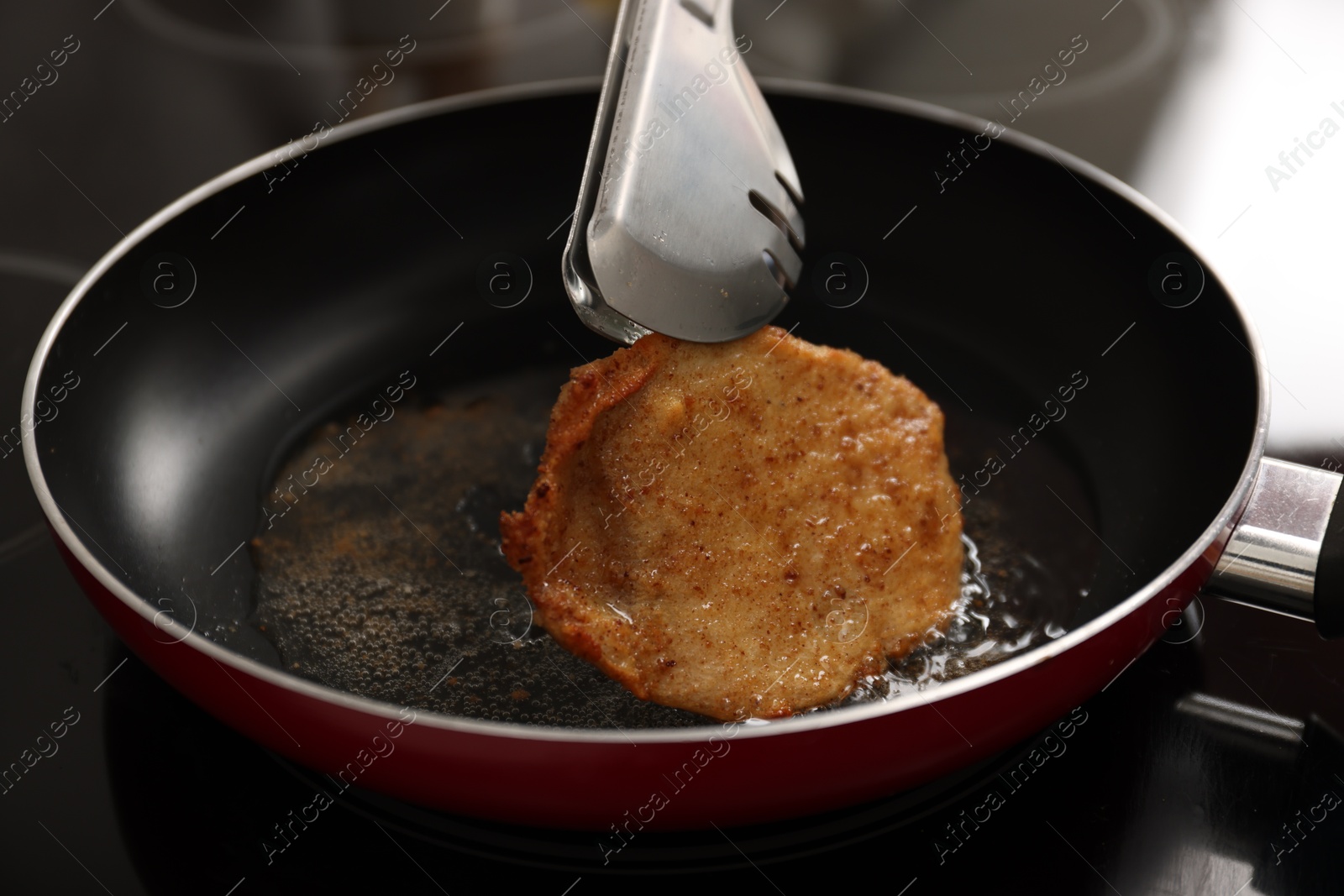 Photo of Cooking schnitzel in frying pan on stove, closeup