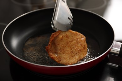 Cooking schnitzel in frying pan on stove, closeup