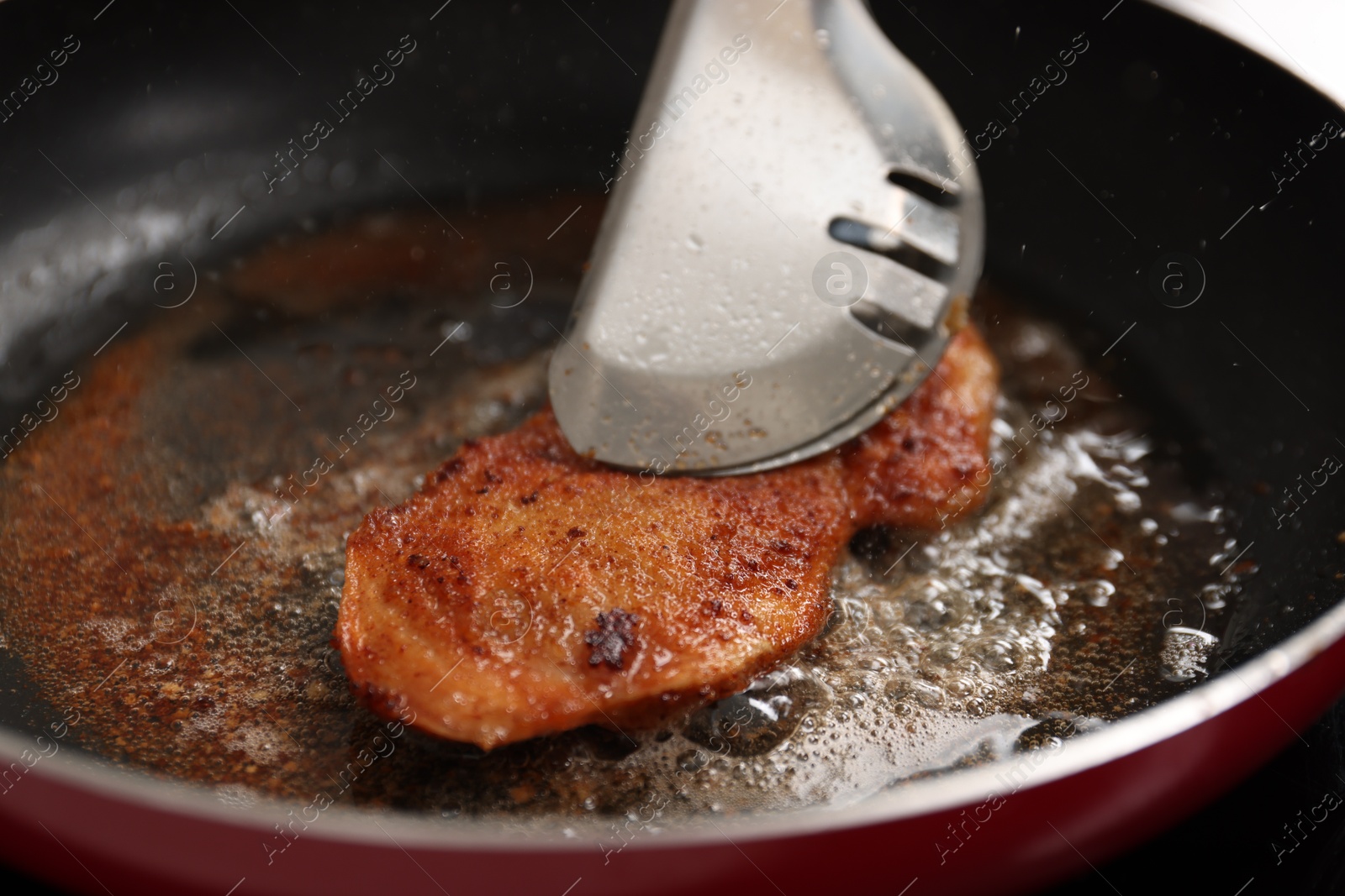 Photo of Cooking schnitzel in frying pan on stove, closeup