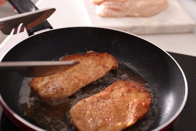 Photo of Schnitzels cooking in frying pan on stove, closeup