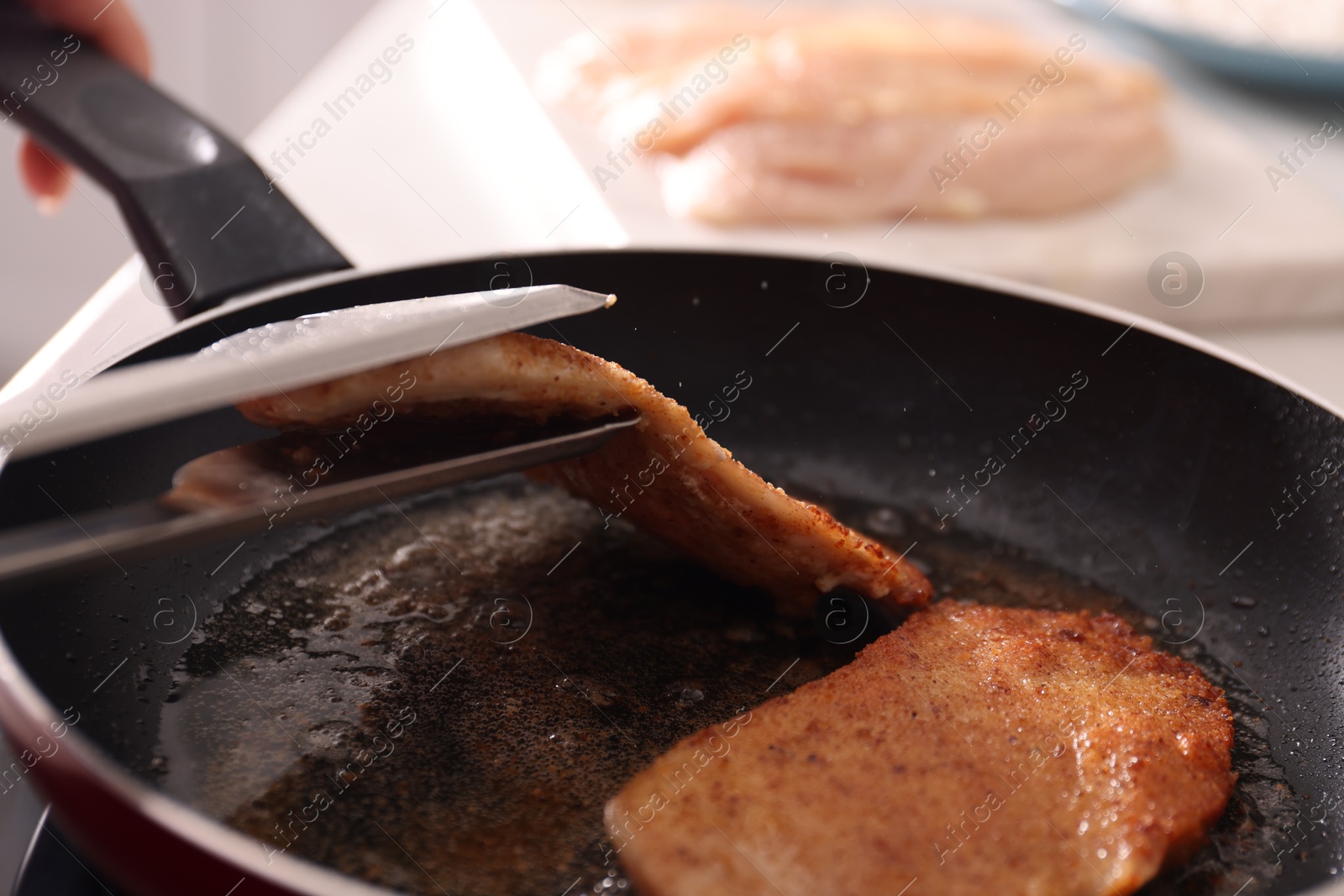 Photo of Schnitzels cooking in frying pan on stove, closeup