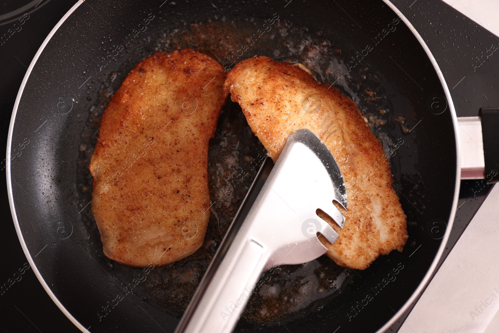 Photo of Schnitzels cooking in frying pan on stove, top view