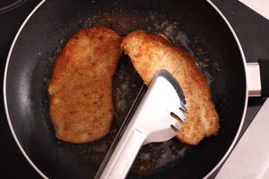 Schnitzels cooking in frying pan on stove, top view