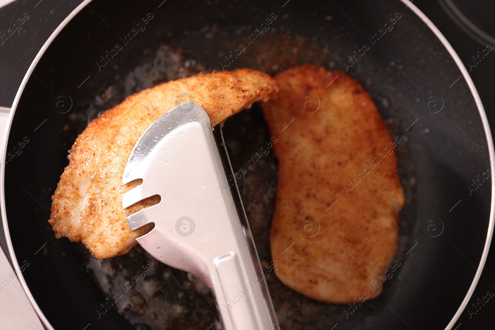 Photo of Schnitzels cooking in frying pan on stove, top view