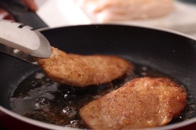 Photo of Schnitzels cooking in frying pan on stove, closeup