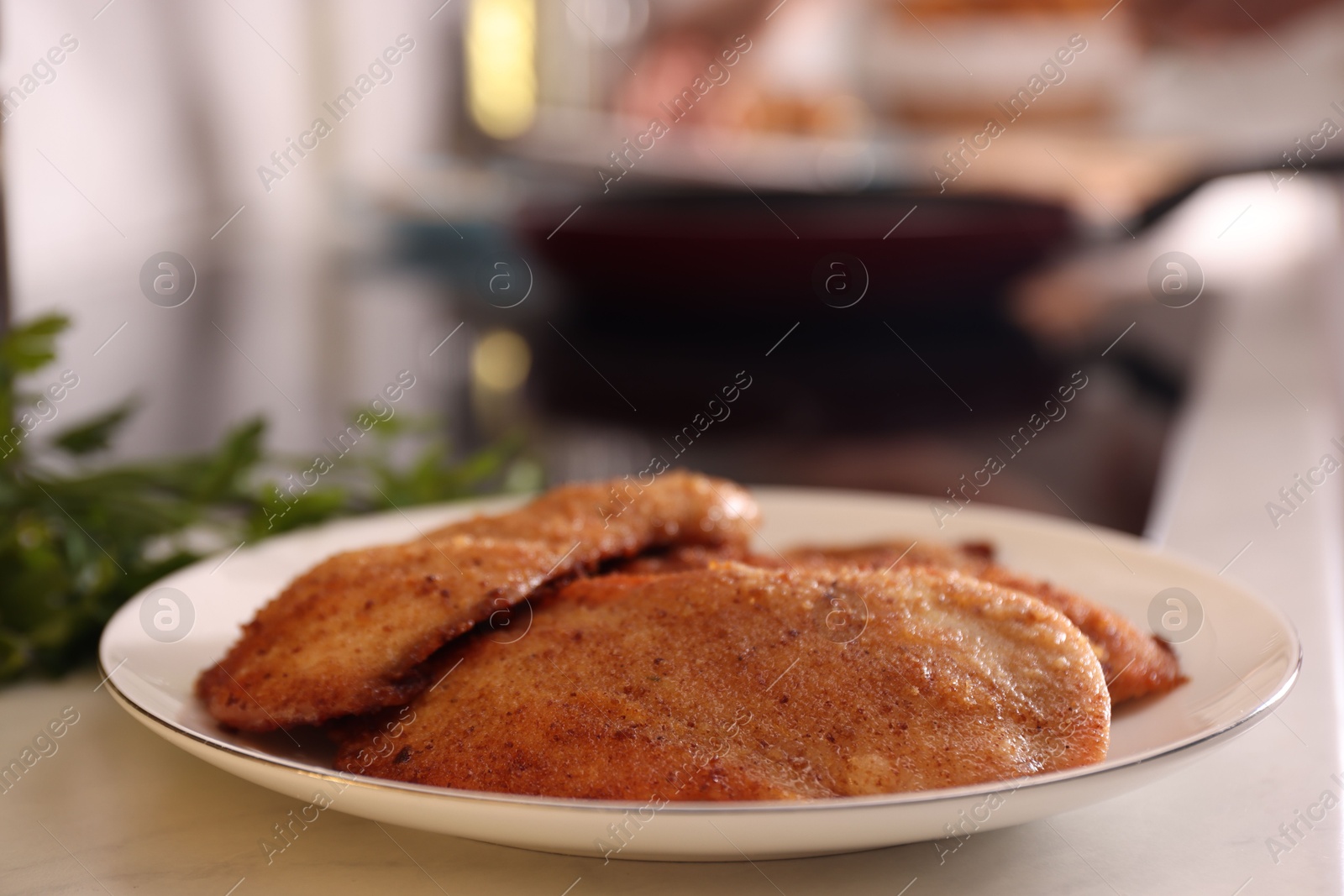 Photo of Plate of tasty schnitzels on table in kitchen, closeup