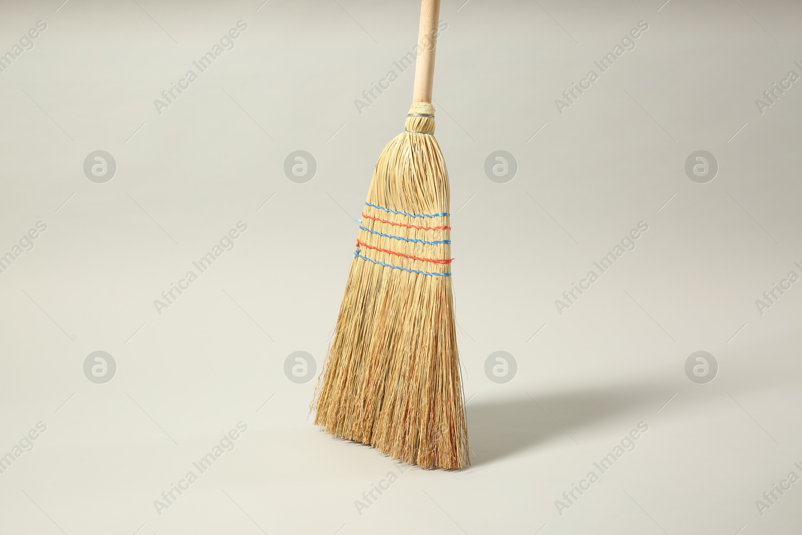 Photo of One corn straw broom on grey background