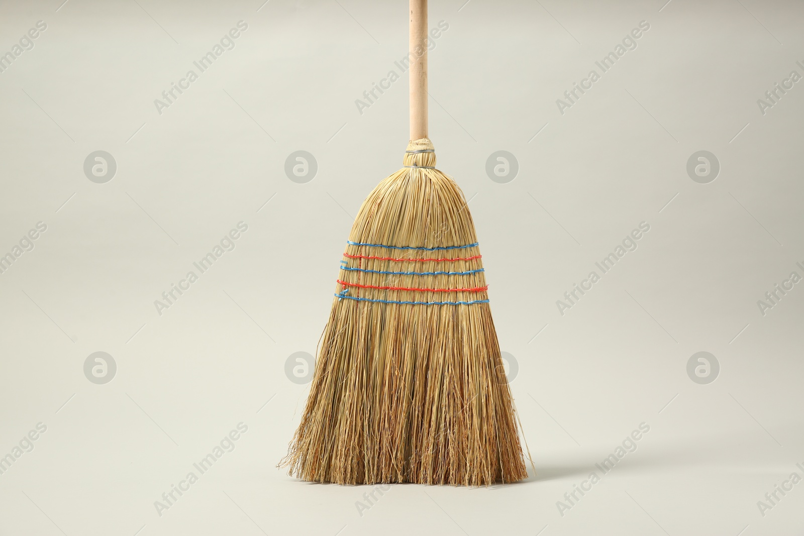 Photo of One corn straw broom on grey background