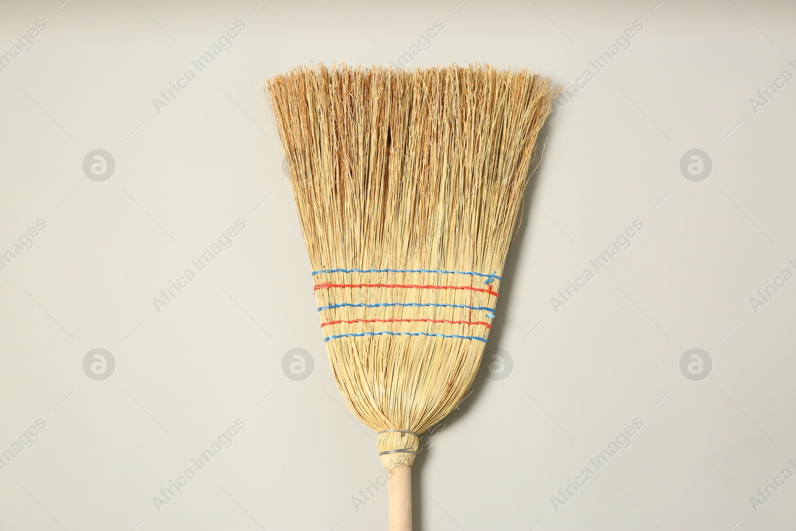 Photo of One corn straw broom on grey background, top view