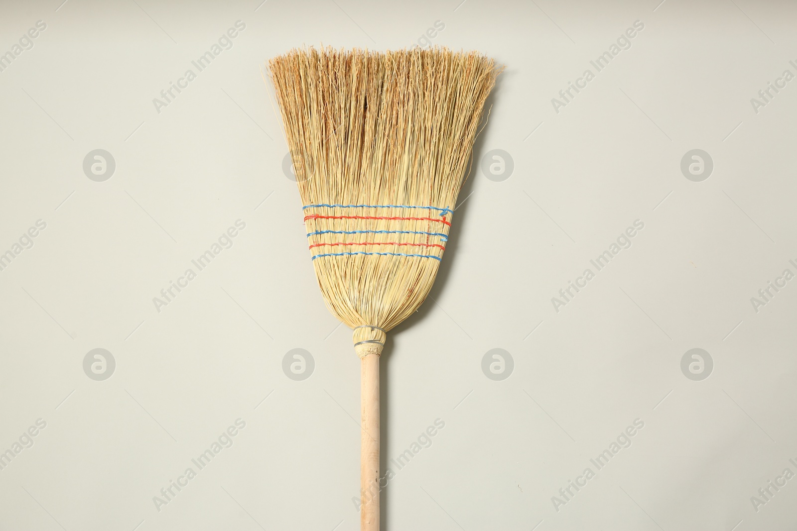 Photo of One corn straw broom on grey background, top view