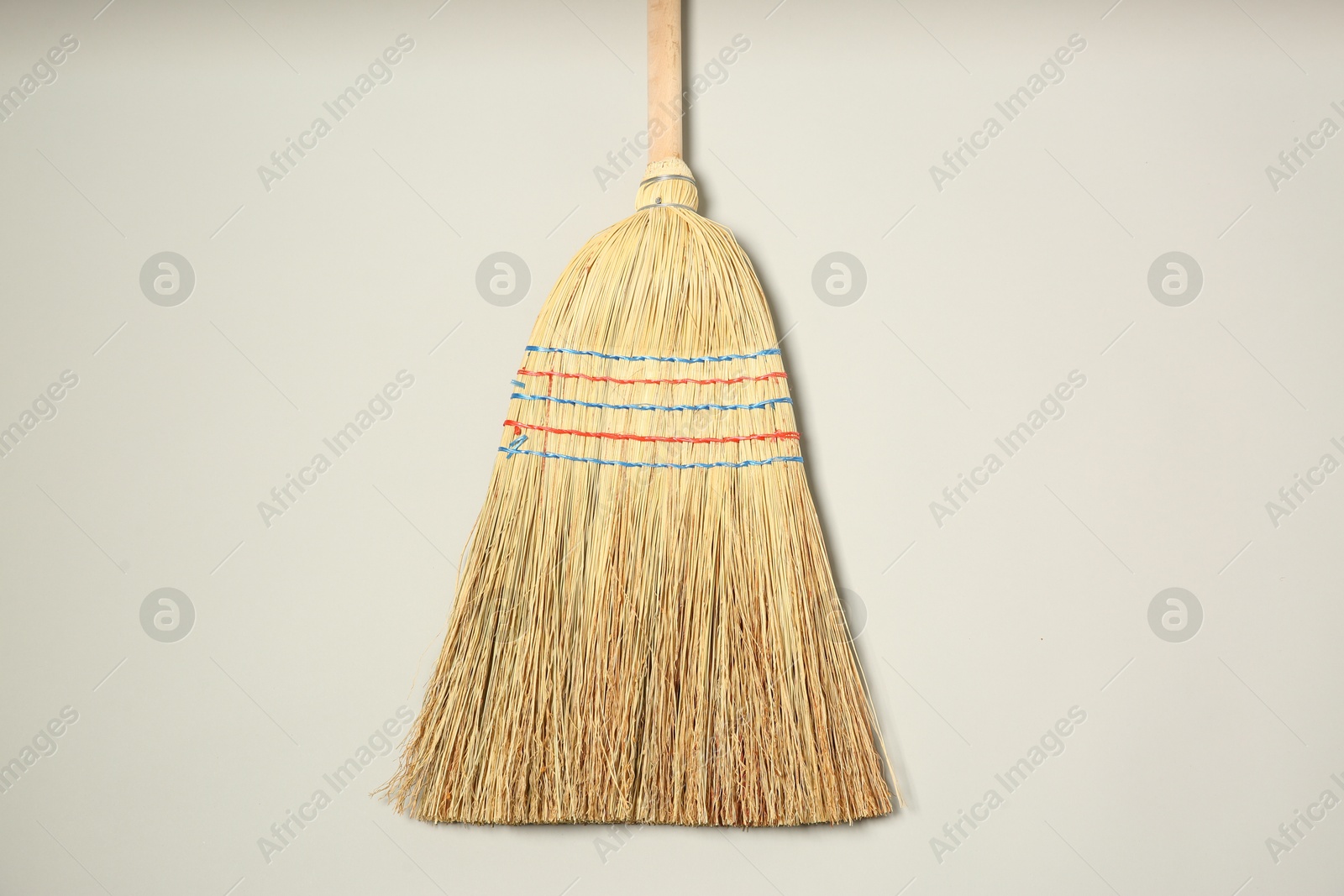 Photo of One corn straw broom on grey background, top view