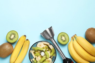 Photo of Hand blender kit and fresh fruits on light blue background, flat lay. Space for text