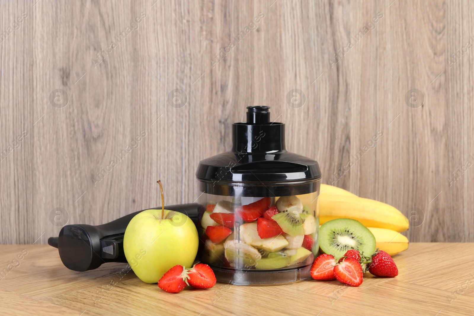 Photo of Hand blender kit, fresh fruits and strawberries on wooden table