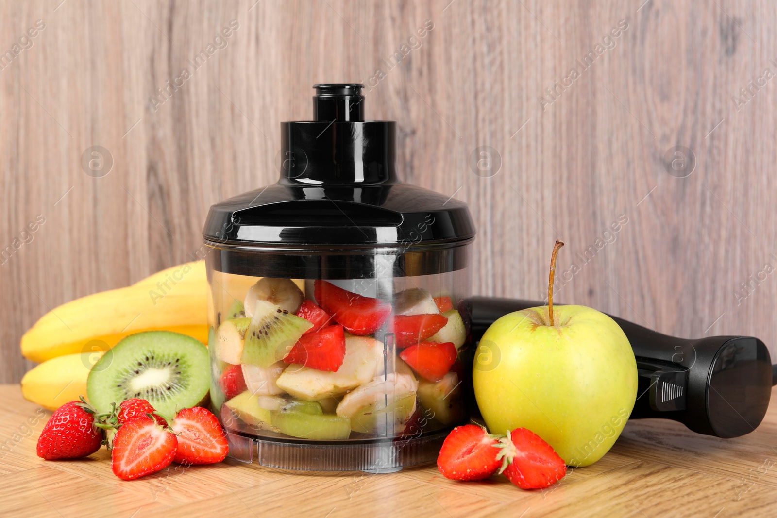 Photo of Hand blender kit, fresh fruits and strawberries on wooden table