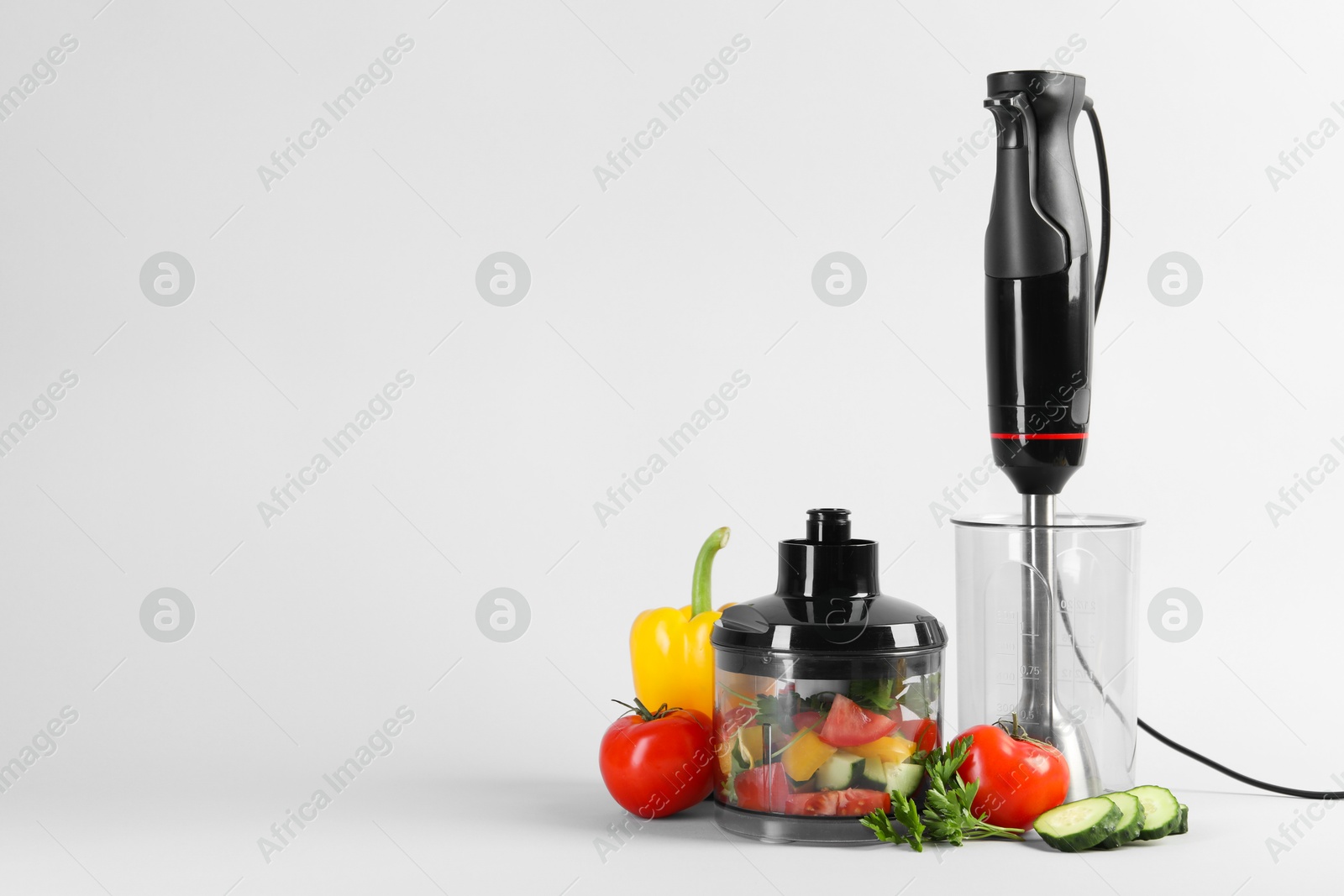 Photo of Hand blender kit, fresh vegetables and parsley on white background, space for text