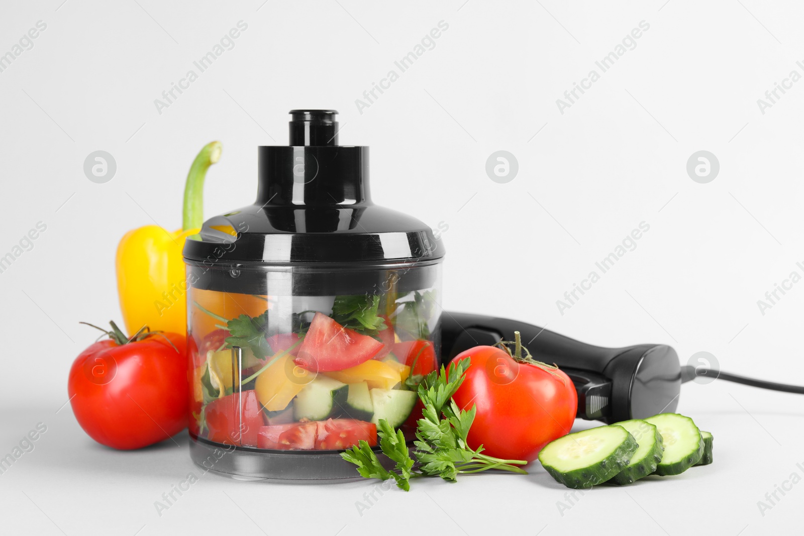 Photo of Hand blender kit, fresh vegetables and parsley on white background