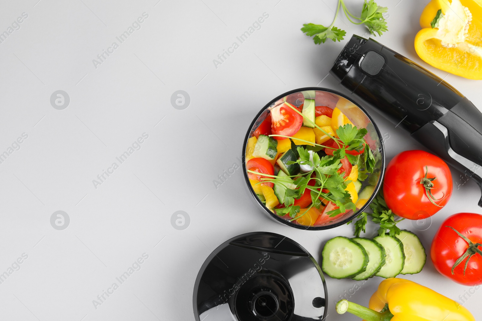 Photo of Hand blender kit, fresh vegetables and parsley on white background, flat lay. Space for text