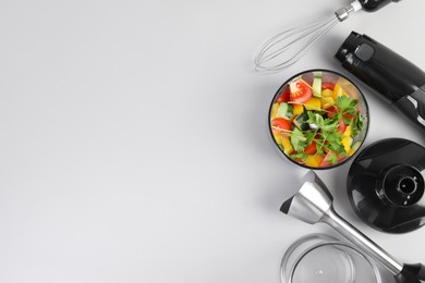 Hand blender kit with fresh vegetables and parsley on white background, flat lay. Space for text