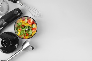 Photo of Hand blender kit with fresh vegetables and parsley on white background, flat lay. Space for text