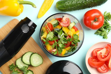 Hand blender kit, fresh vegetables and parsley on light blue background, flat lay