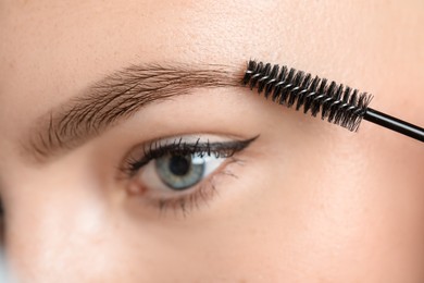 Photo of Young woman with spoolie brush, closeup. Eyebrow correction
